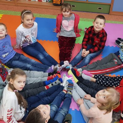 Dzieci prezentują skarpetki - symbol Światowego Dnia Osób z Zespołem Downa