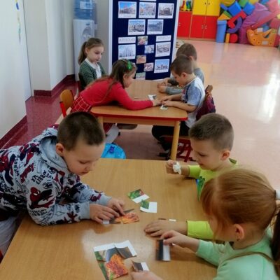 Dzieci z grupy 0c układają puzzle z włoskimi potrawami