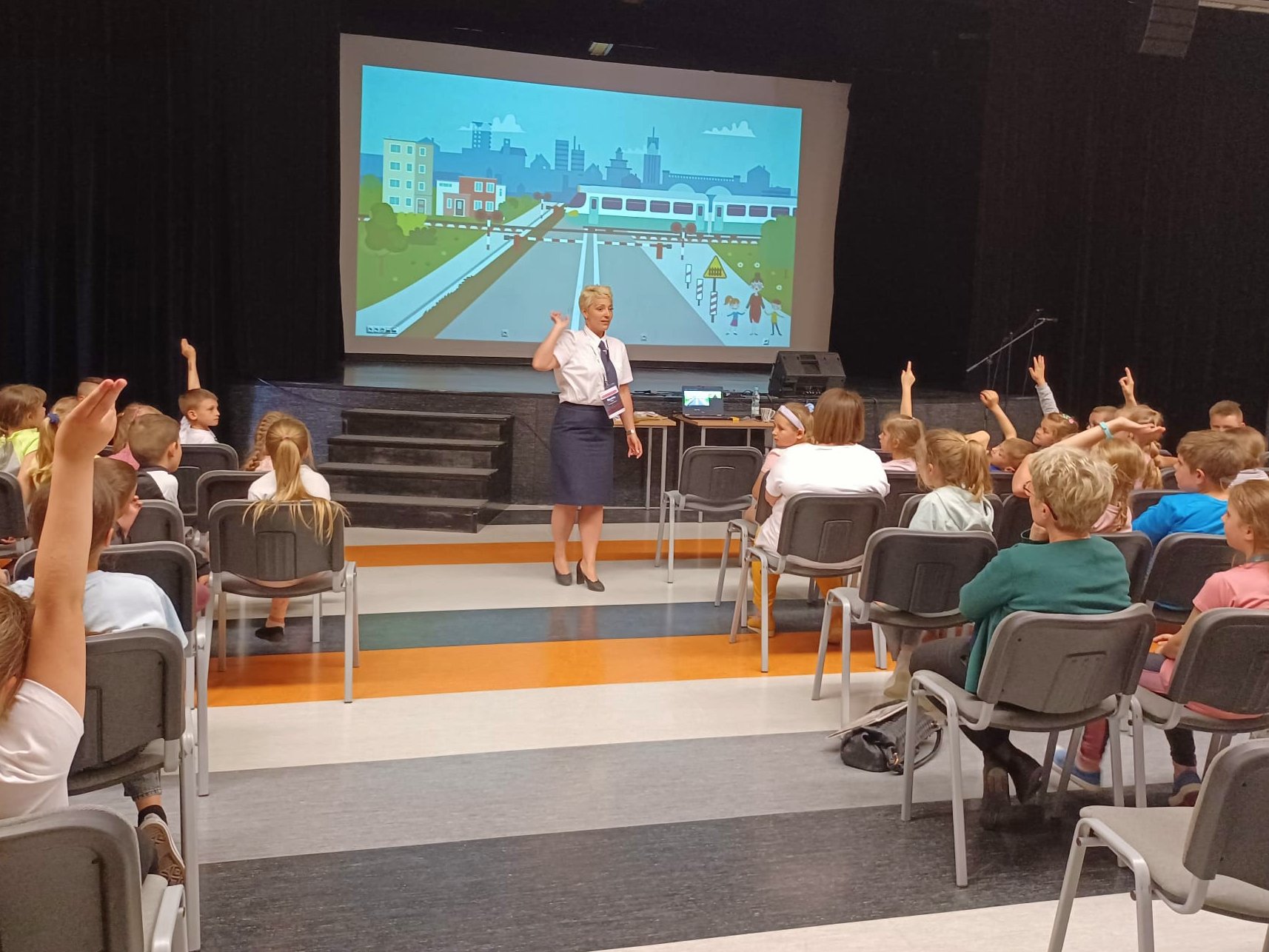 prowadząca omawia kwestie bezpieczeństwa na przejazdach kolejowych