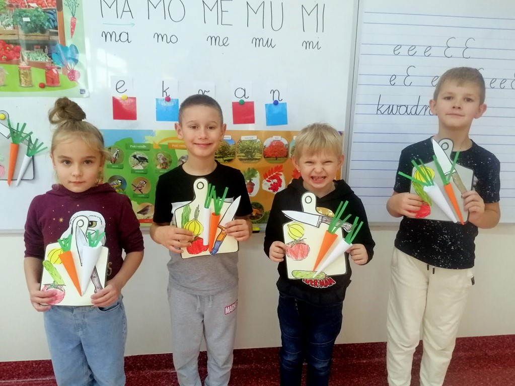 Uczniowie prezentują wykonane przez siebie prace plastyczno-techniczne: deski z warzywami