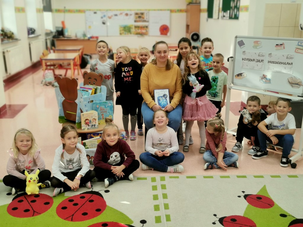 Zerówkowicze wraz z rodzicem na pamiątkowym zdjęciu po przeczytaniu książki