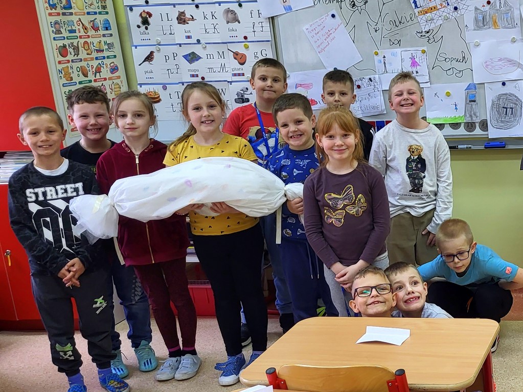 Uczniowie pozują z dużym cukierkiem podczas zajęć