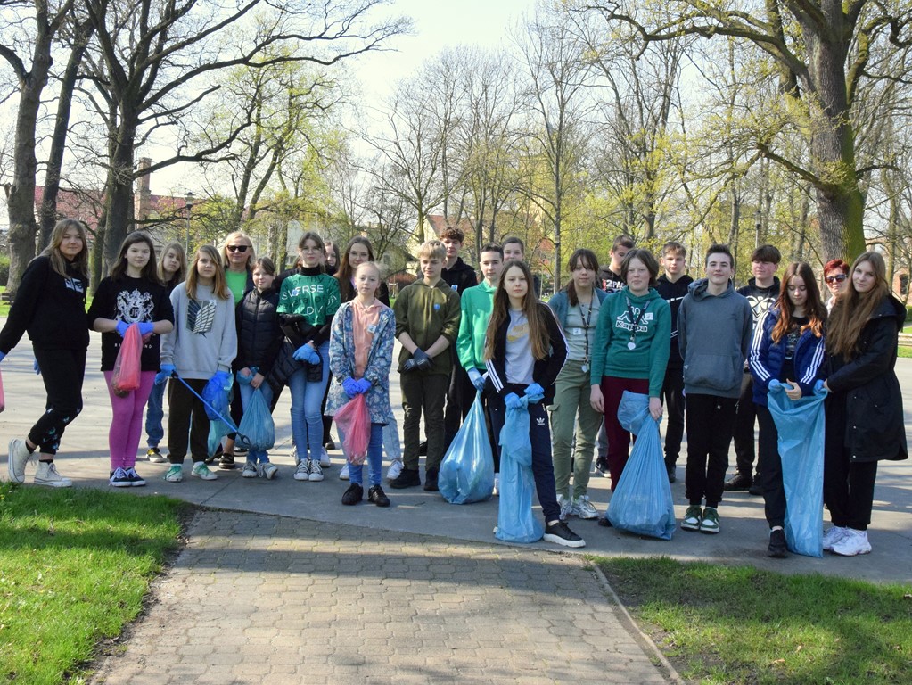 Pamiątkowe zdjęcie wolontariuszy wraz z nauczycielkami po akcji sprzątania parku