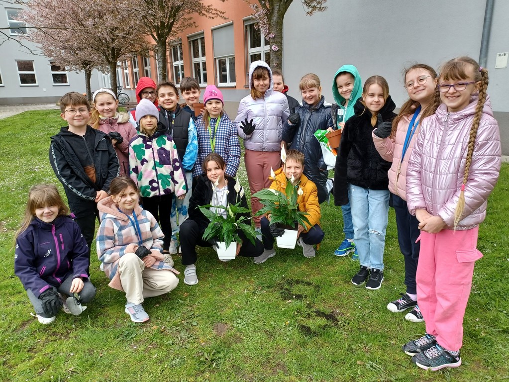 Uczniowie z klasy trzeciej na pamiątkowym zdjęciu po wsadzeniu skrzydłokwiatu